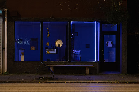 view of the gallery from outside with the lights off, only LED lights showing