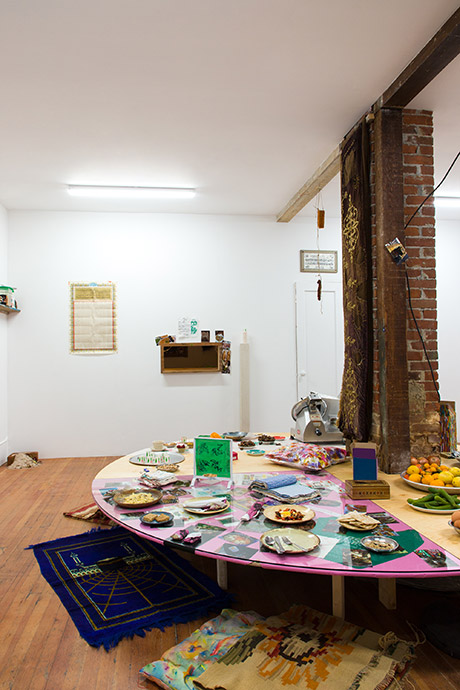 the central table work with cushions and rugs around it for gallery comers to sit around while they are served the foods of the artists